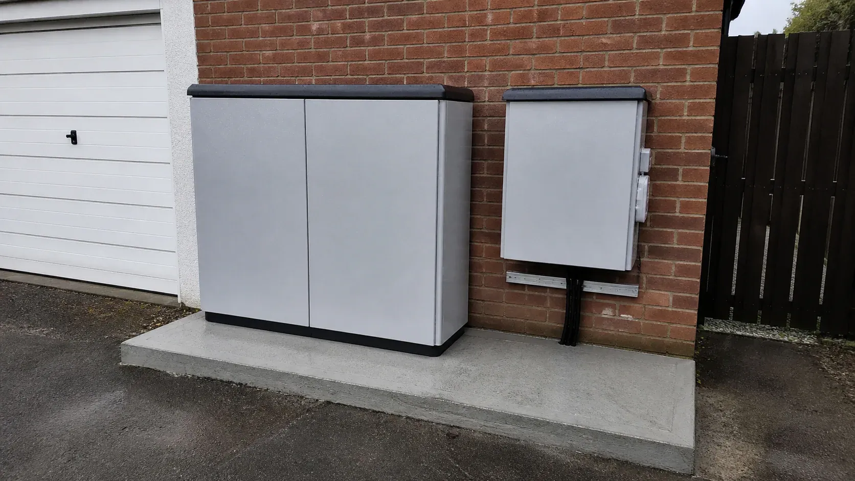 Weatherproof outdoor battery storage cabinet on a level concrete pad