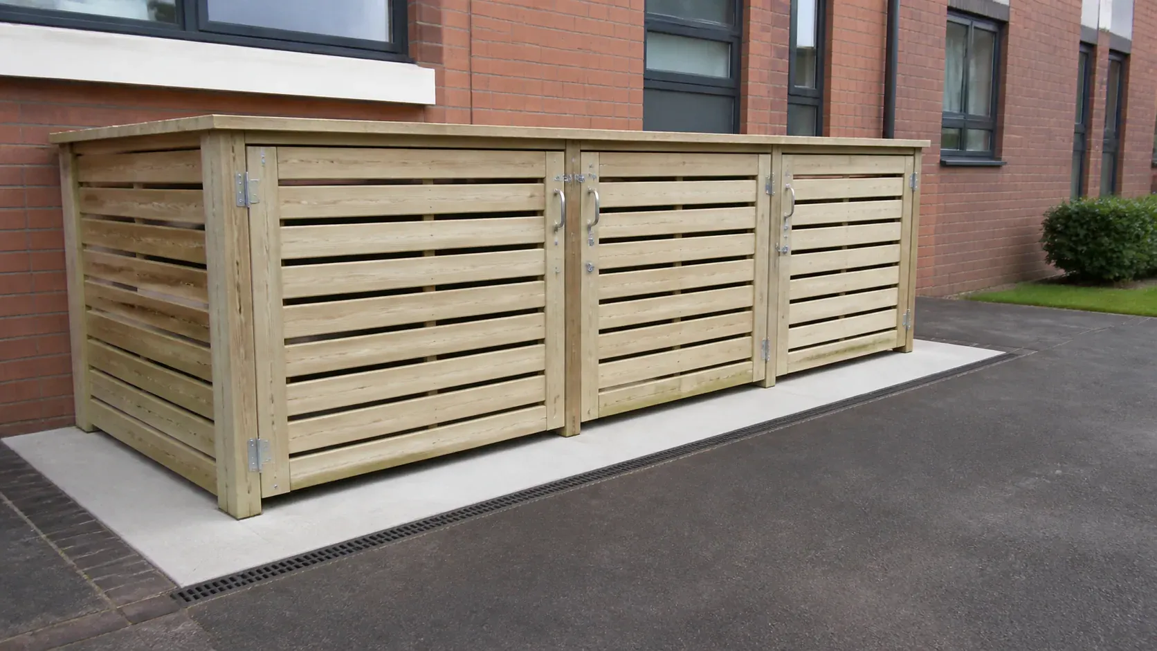 Timber bin store and wheelie bins on a clean paved base