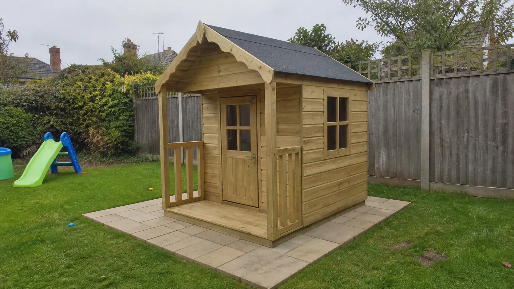 Timber children's playhouse on a tidy base in a family garden
