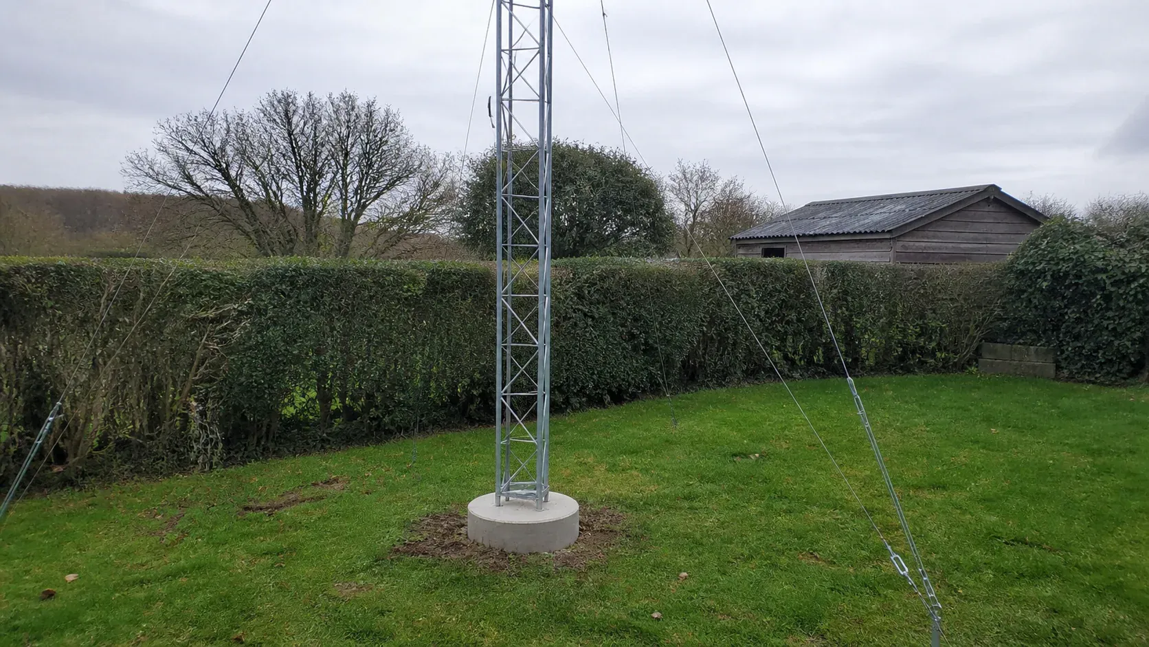 Garden amateur radio mast secured to a concrete base