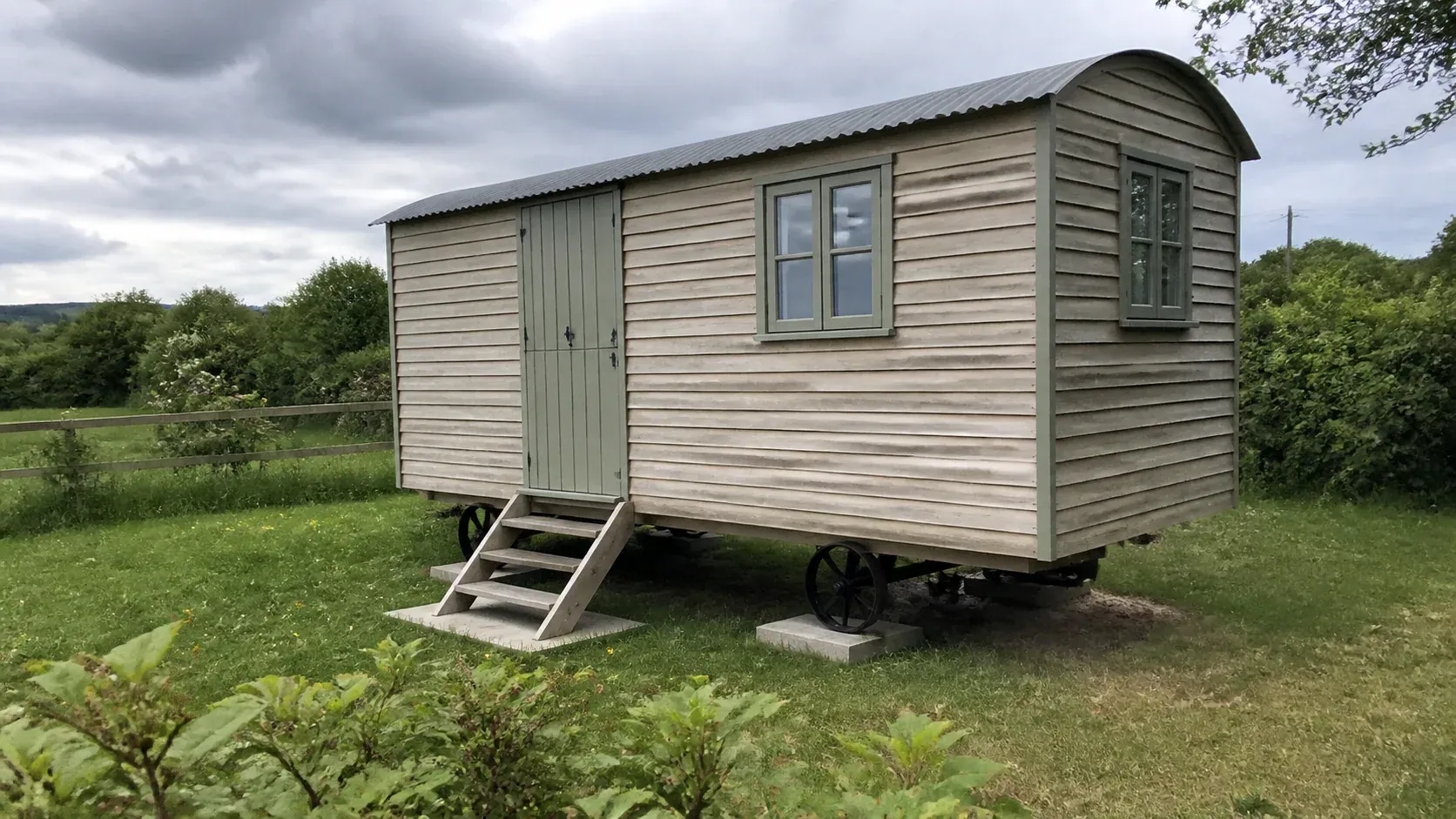 Traditional shepherd hut standing level on prepared supports in a field