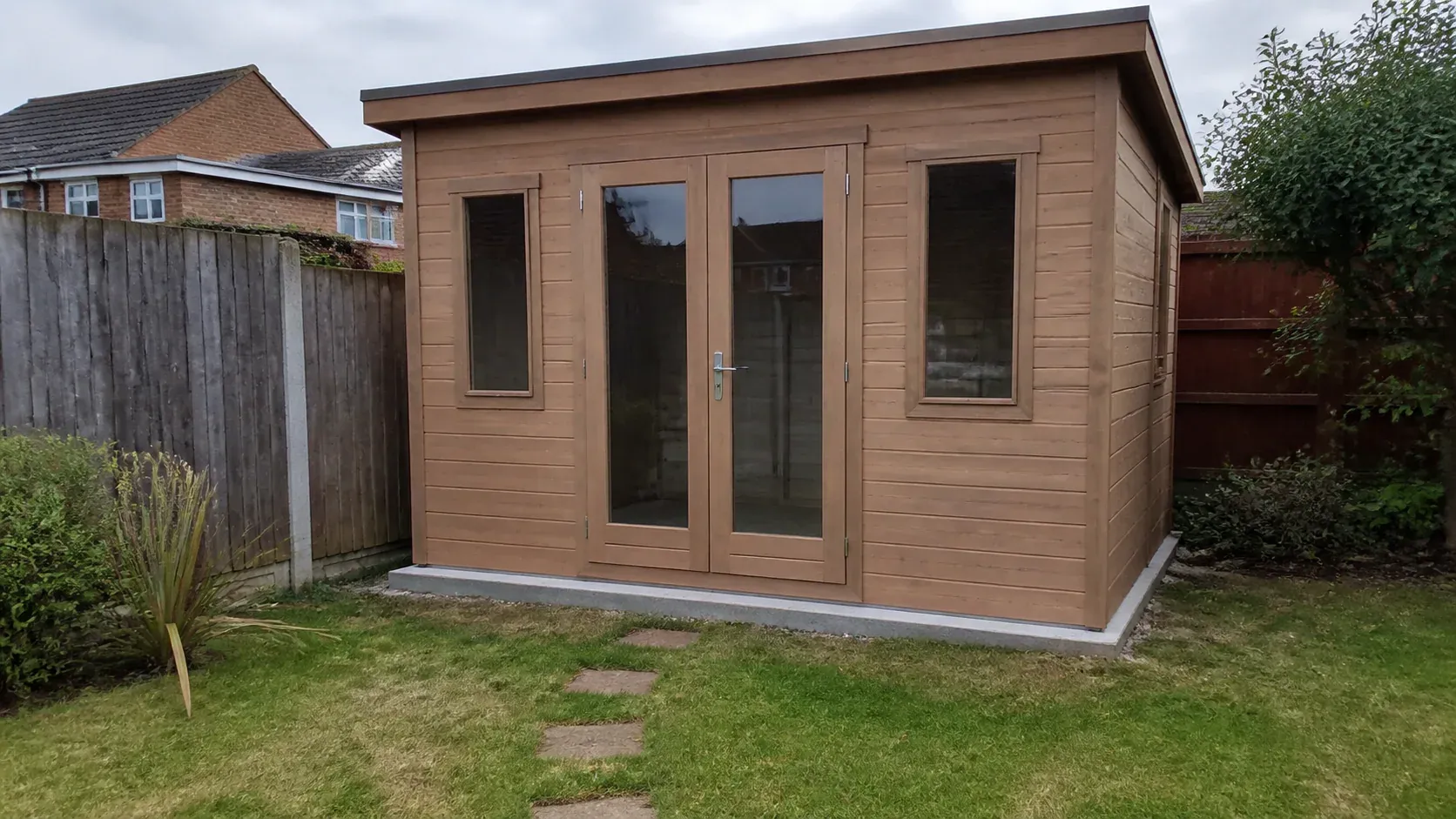 Timber summerhouse standing level in a typical British garden