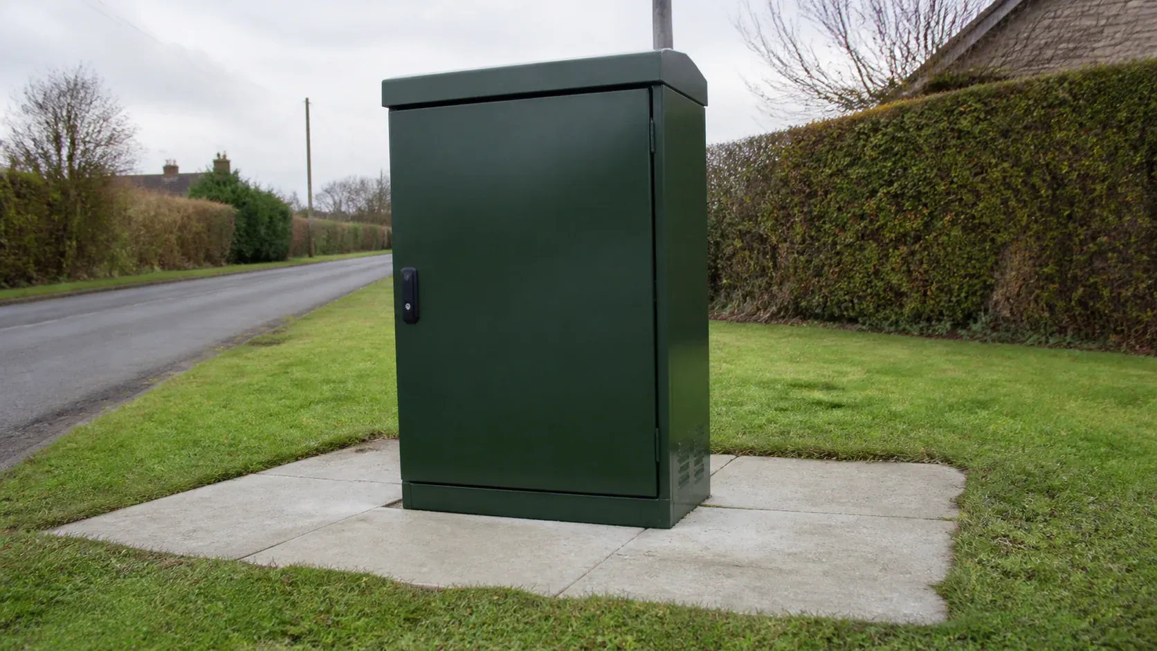 Street-side telecommunications cabinet secured to a concrete plinth
